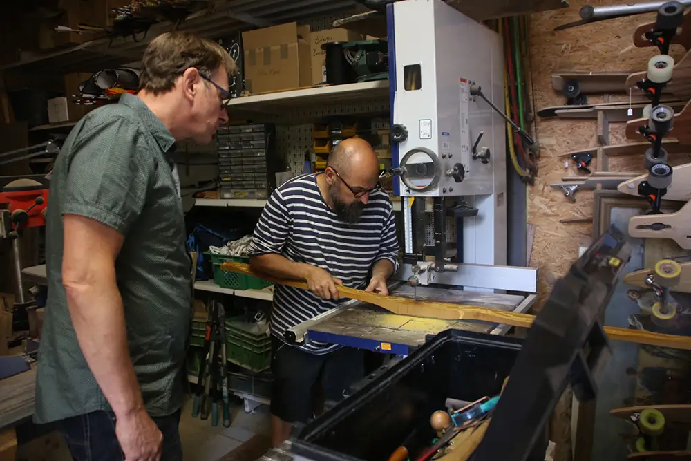 Mann s&auml;gt einen Bogen an der Bands&auml;ge