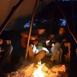 Menschen singen am Lagerfeuer