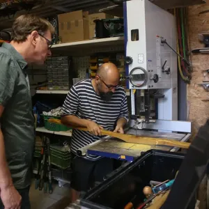 Mann s&auml;gt einen Bogen an der Bands&auml;ge