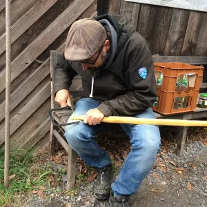 Mann bearbeitet einen primitiven Bogen