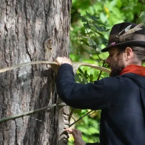 Mann baut einen Holzbogen